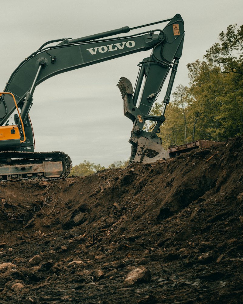Excavator digging into a bank of earth on a building site