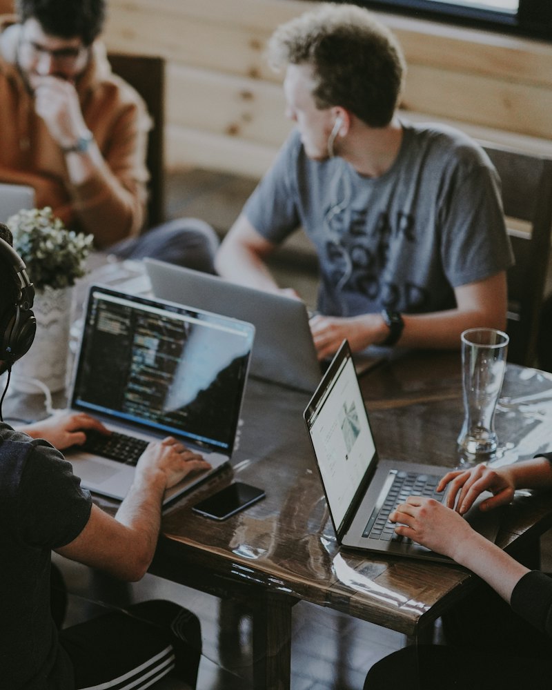 Software team working together on laptops around a shared table